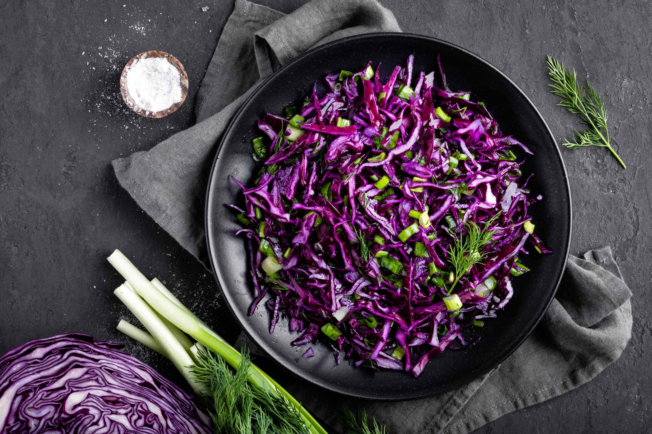 Red cabbage salad with fresh green onion and dill. Vegetarian dish.
