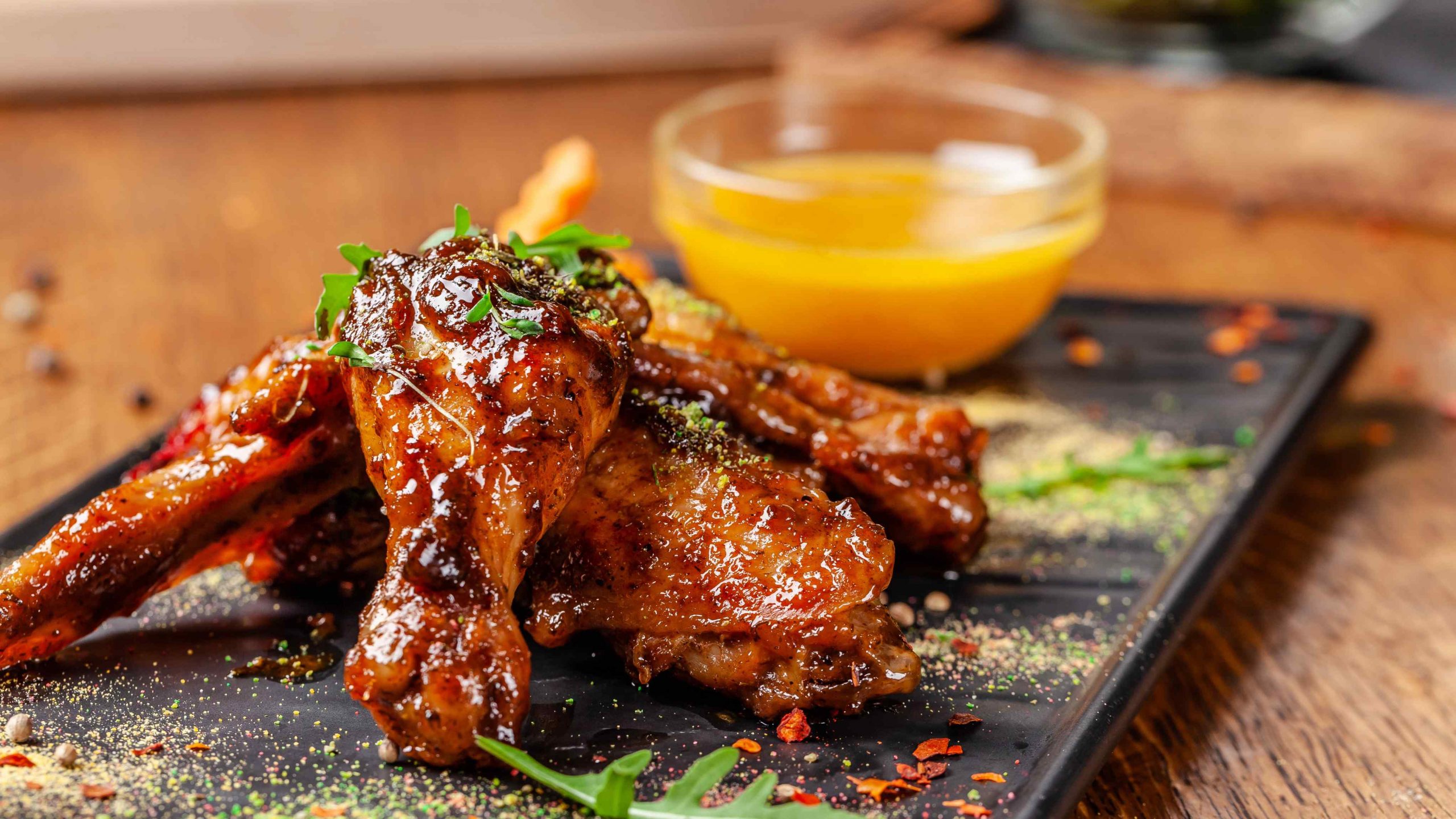 concept-indian-cuisine-baked-chicken-wings-legs-honey-mustard-sauce-serving-dishes-restaurant-black-plate-indian-spices-wooden-table-background-image